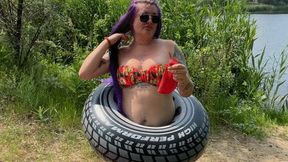 Girl on beach blowing big balloon with nailpop