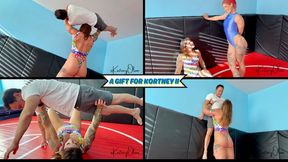 A Gift For Kortney II - Stella Skye Brings Kortney Olson a Small Man To Lift & Carry For Her Birthday - Bench Presses, Wall Lifts, and Overhead Presses Are All Used - UltraHD (WMV)