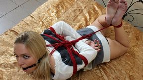 Ballgagged barefoot Alina in black and white dress, hogtied with red hemp rope, wiggles and rolls on the bed (HD MP4)