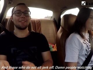 Cutie jerks off a man and masturbates herself during the time that driving