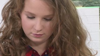 A curly brunette that has pretty boobs is getting a dick in her face