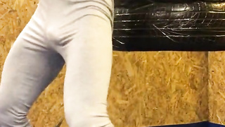 Мускулистая круглая задница натурала в серых лосинах на тренировке по боксу....