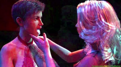Two women tease and swallow cum from a muscular man during a sensual striptease