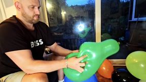 Tom hand pops a pile of under-inflated balloons