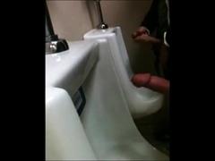 two slim dicks getting wanked at the urinals