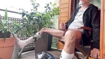 Hairy guy smokes and jerks his big cock on the balcony