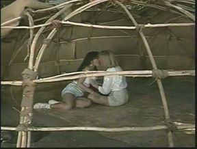 A blonde and a brunette go lesbian in a tent in retro porn clip