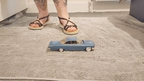 Giantess Jayne Vs 1960s Chevrolet Impala toy car crush in flat sandals ground view