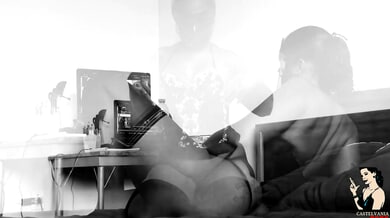Curvy dark-haired woman in black corset works on laptop in dim bedroom