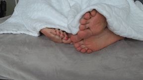 Intertwining toes under the blanket A d