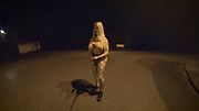 A transvestite runs naked in public with two penises.