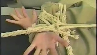 Een cosplayer van een politieagent is vastgebonden en heeft een balgag in zijn mond.