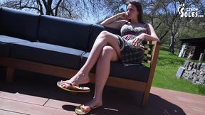 Flip flops and long toes relax on terrace
