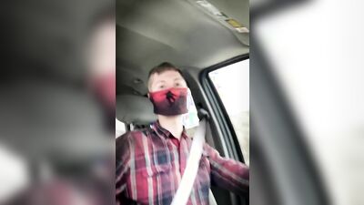 Amateur masked bloke is having fun while driving a car