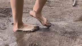A girl in the forest walks barefoot on a wet, muddy path (reissue)