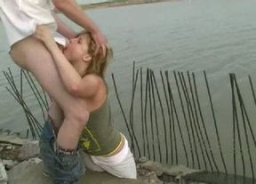 Lusty blonde harlot sucks two hard dicks near the lake