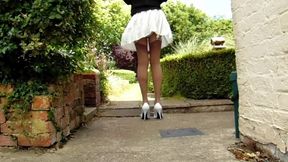 Tan stockings with pleated skirt on a windy day