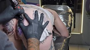 Stunning blonde with big round ass and anal tattoo gets her tight pussy pierced