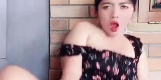 Neng Susi performs live while running a store