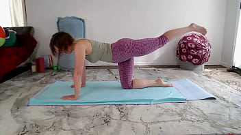 Goddess Aurora Willows bends over in yoga class