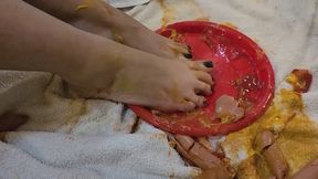 Dirty feet squeezing a hot dog through toes
