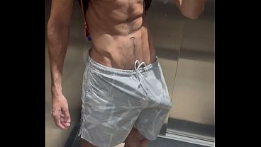 Huge hard cock in shorts without underwear in the elevator