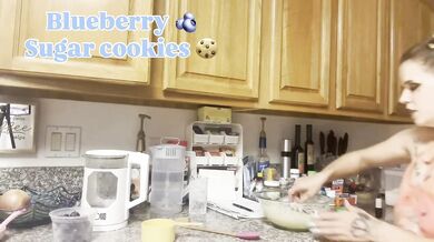 Blonde baker knees against the counter gushing filming a kitchen scene solo