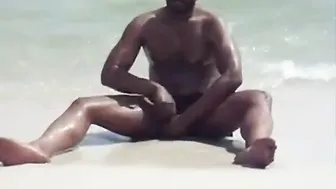 Black amateur strokes his big cock on a public beach