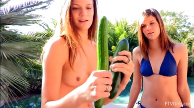 Two women explore anal play with a cucumber on a sun-drenched patio