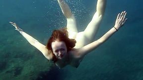 Cute redhead teen babe in the open blue sea underwater