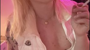 Transgirl smokes a cigarette in nothing but a white shiny down vest