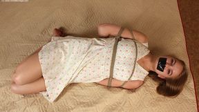 Irene: tapegagged barefoot girl, wearing old-fashioned dress, hogtied with hemp rope, is wiggling on a mattress, trying to loosen her bonds (HD MOV)