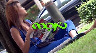 Thai woman with smooth legs straddles a tattooed white man on a beige couch