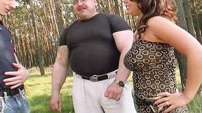 A sexy brown-haired German lady enjoys teasing two erect dicks al fresco
