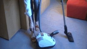 Madame Caren vacuuming carpet in clogs with white vacuum cleaner