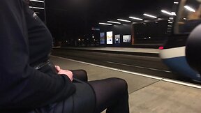 Nighttime tram station display by a crossdresser