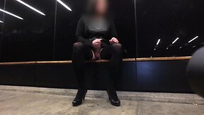 Nighttime tram station display by a crossdresser