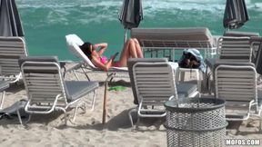 Beautiful and sexy dark-haired minx rests on the beach