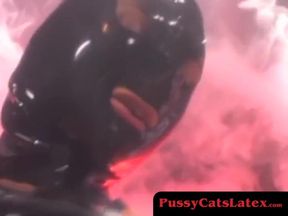 Latex-clad dominatrix toys her submissive's pussy