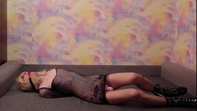 Sissy crossdresser bound in armbinder and gagged lying on couch