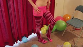 Riann changing some clothes and surrounded by balloons