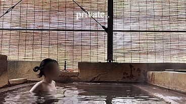 Japanese girl bathing in a mixed outdoor bath at a hot spring inn