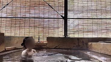 Japanese girl bathing in a mixed outdoor bath at a hot spring inn