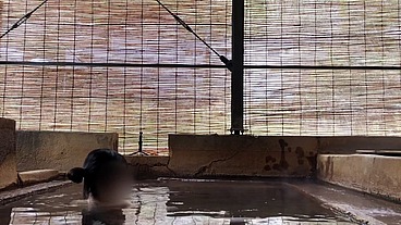 Japanese girl bathing in a mixed outdoor bath at a hot spring inn