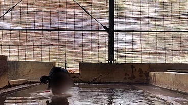 Japanese girl bathing in a mixed outdoor bath at a hot spring inn