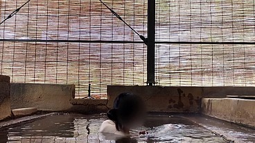 Japanese girl bathing in a mixed outdoor bath at a hot spring inn