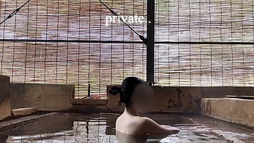 Japanese girl bathing in a mixed outdoor bath at a hot spring inn