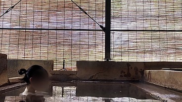 Japanese girl bathing in a mixed outdoor bath at a hot spring inn