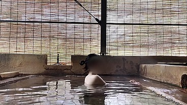 Japanese girl bathing in a mixed outdoor bath at a hot spring inn