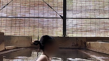 Japanese girl bathing in a mixed outdoor bath at a hot spring inn